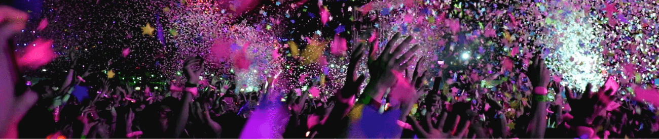 Pink Confetti Showering a Crowd of People Partying with their Hands in the Air