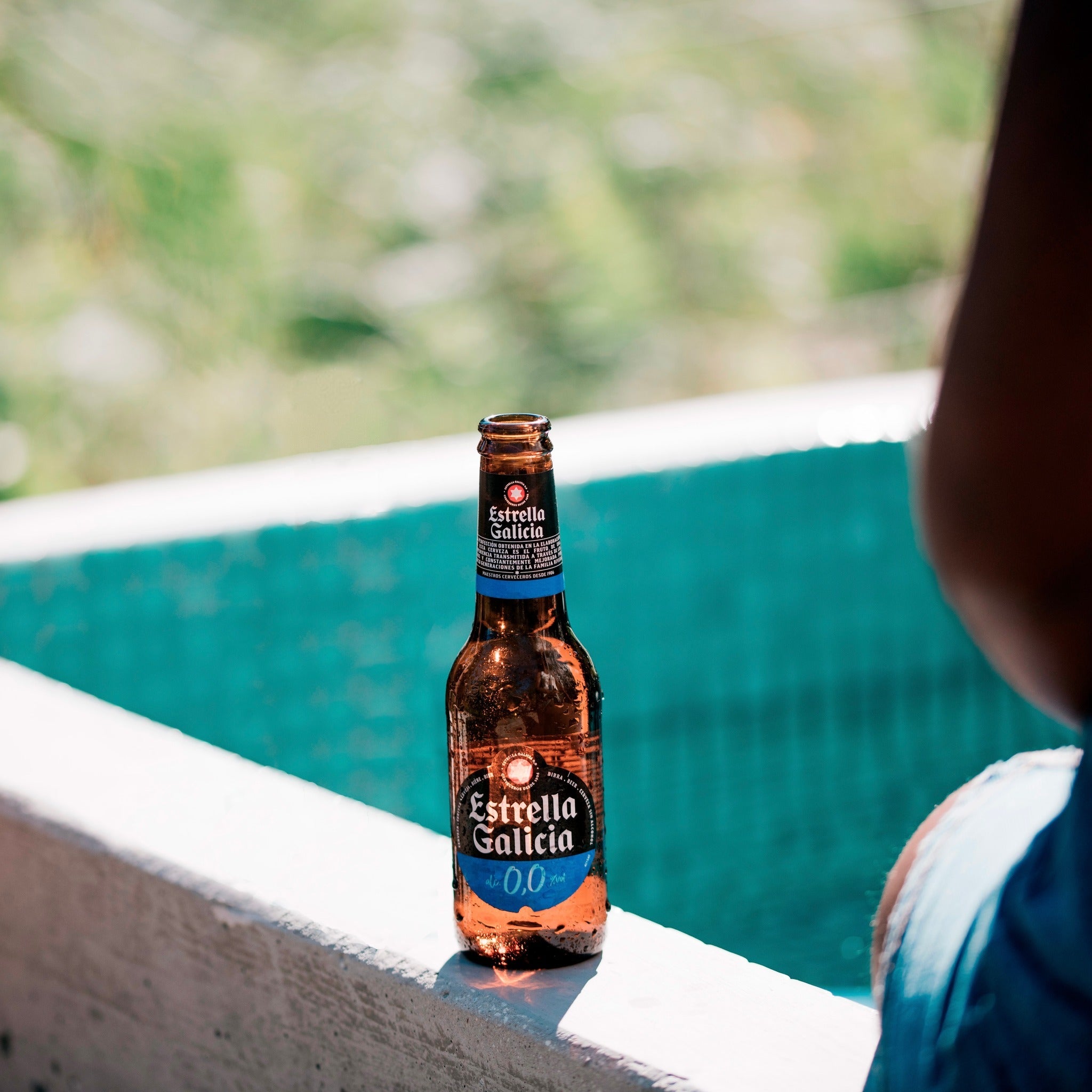 Bottle of Estrella by the pool